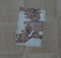 Partial Gustav Stickley paper label signature on the original canvas supporting the leather seat.